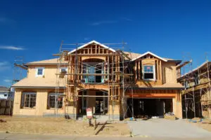 A house under construction with scaffolding around the roof.