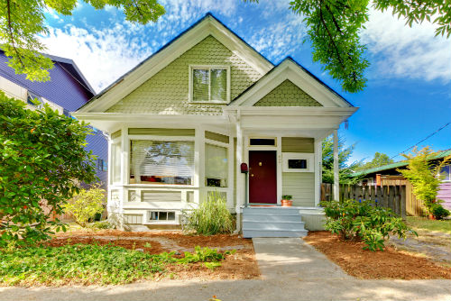 A green house with red door and white trim.