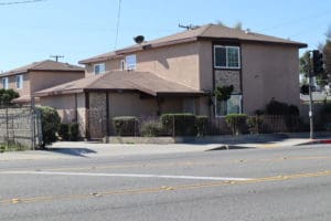 A brown house sitting on the side of a road.