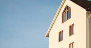 A white house with two windows and a blue sky