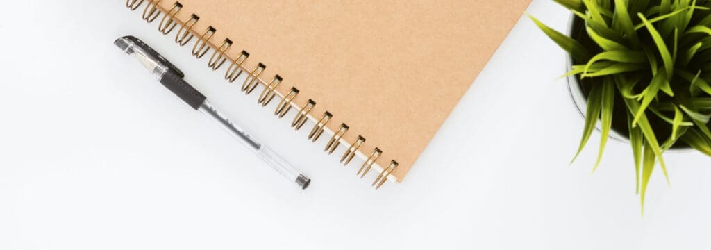 A notebook with bullet holes and a pen.