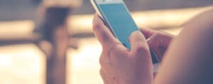 A person holding their cell phone in one hand.