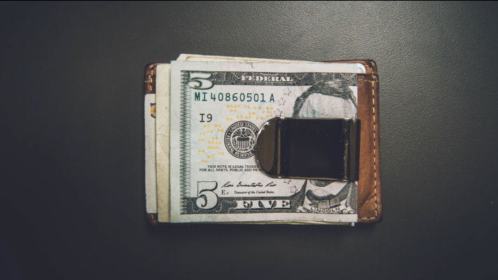 A close up of a wallet with money sticking out