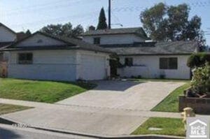 A house with grass on the front and side of it.