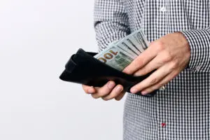 A man holding a wallet with money in it.