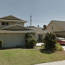 A house with a car parked in front of it.