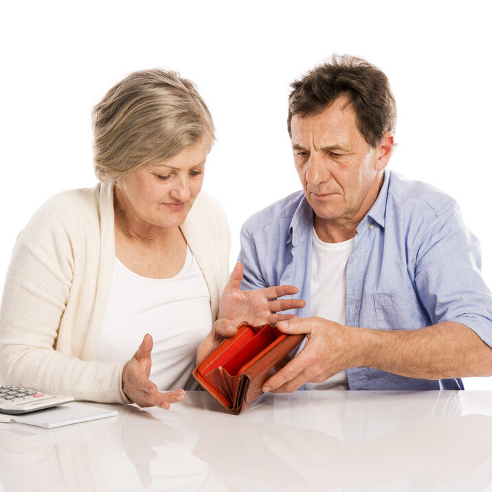 A man and woman looking at an item in their purse.