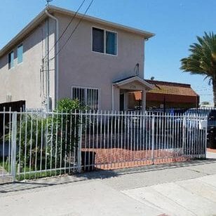 A fence that is attached to the side of a house.