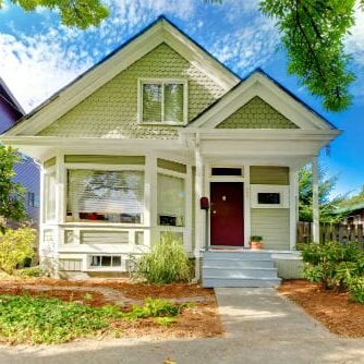 A green house with red door and white trim.