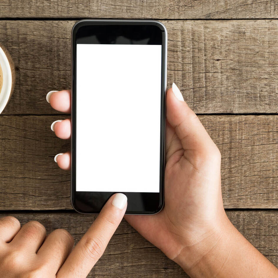Smartphone with blank screen near coffee cup