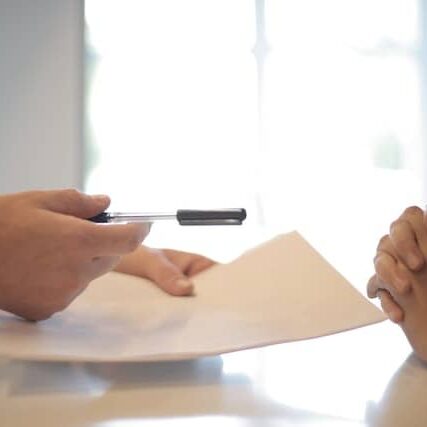 pexels-andrea-piacquadio-3760067 (1) A person is signing papers with someone else.