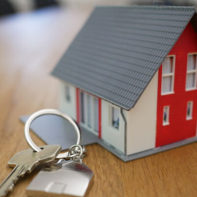 A key is sitting in front of a model house.