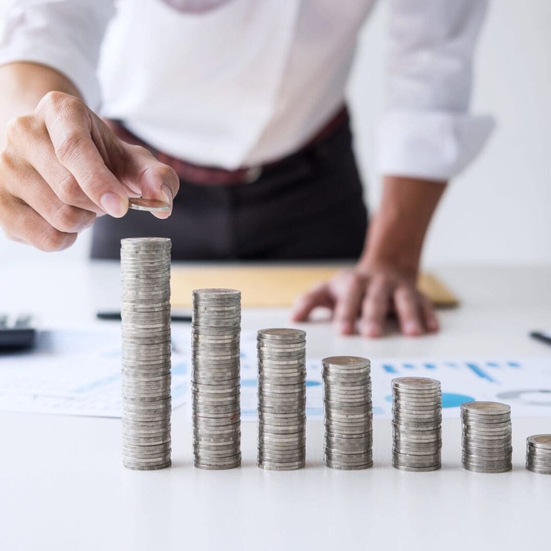 A man is stacking coins on top of the table.